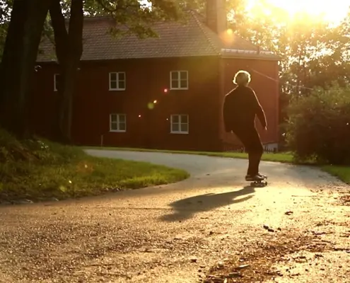 Vilmer Bäckman åker skateboard ner för en backe i motljus