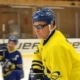 Blind Ice Hockey, man i gulblå hockeytröja, hjälm och mörka glasögon