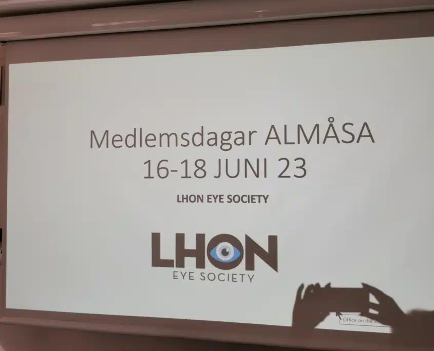 vi projektorbild med svart text "Medlemsdagar Almåsa 16-18 JUNI 2023". Under syns LHON Eye Society logotyp